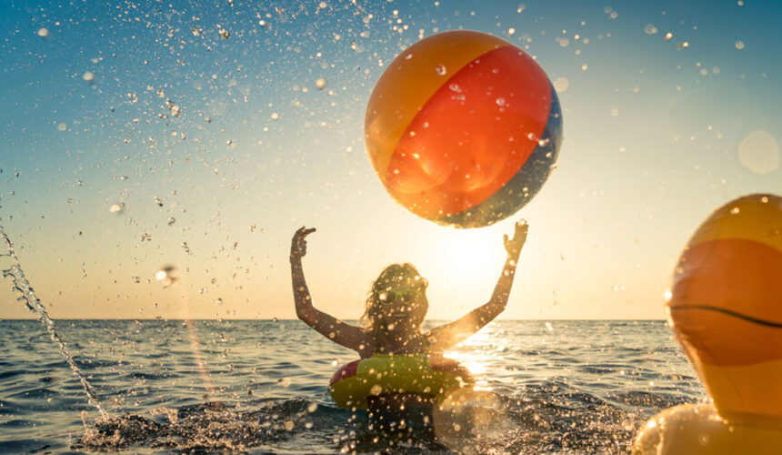 happy-child-having-fun-on-summer-vacation-kid-playing-with-rubber-duck-and-ball-in-the-sea